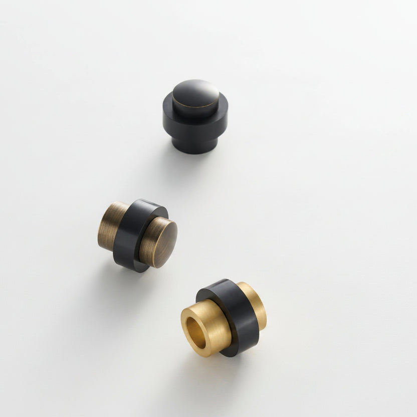 Three-piece view of round door stop: black cap with gold metal core