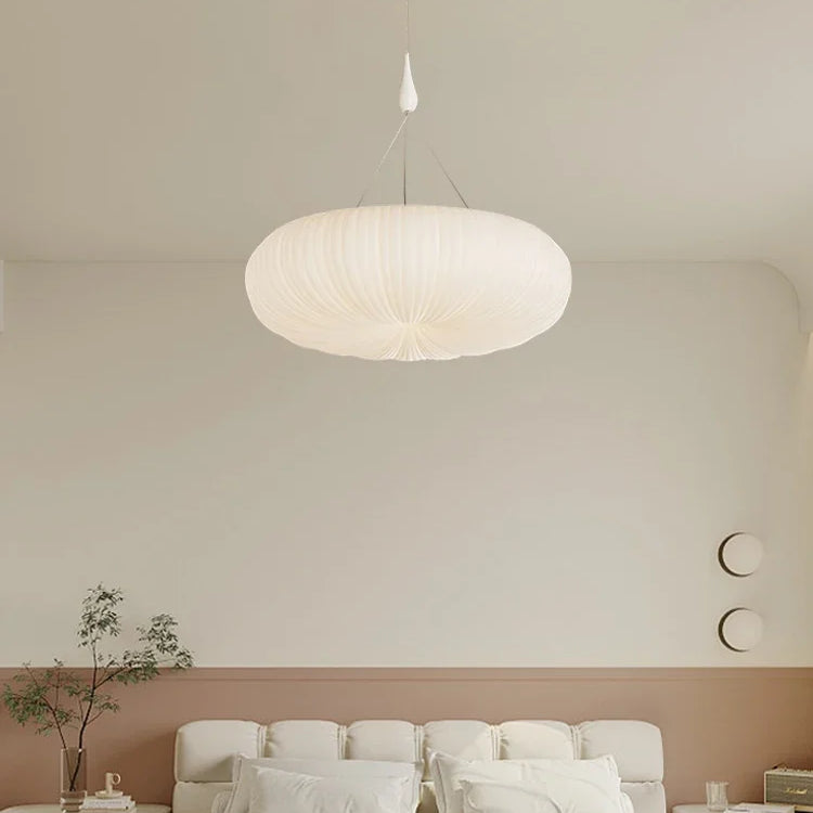 Cream pendant ceiling light with ribbed dome shade above a bed