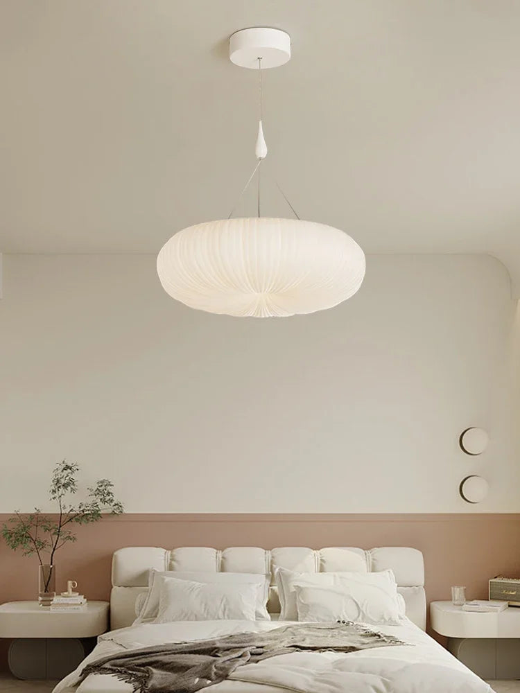 Cream pendant ceiling light with ribbed dome shade above a bed