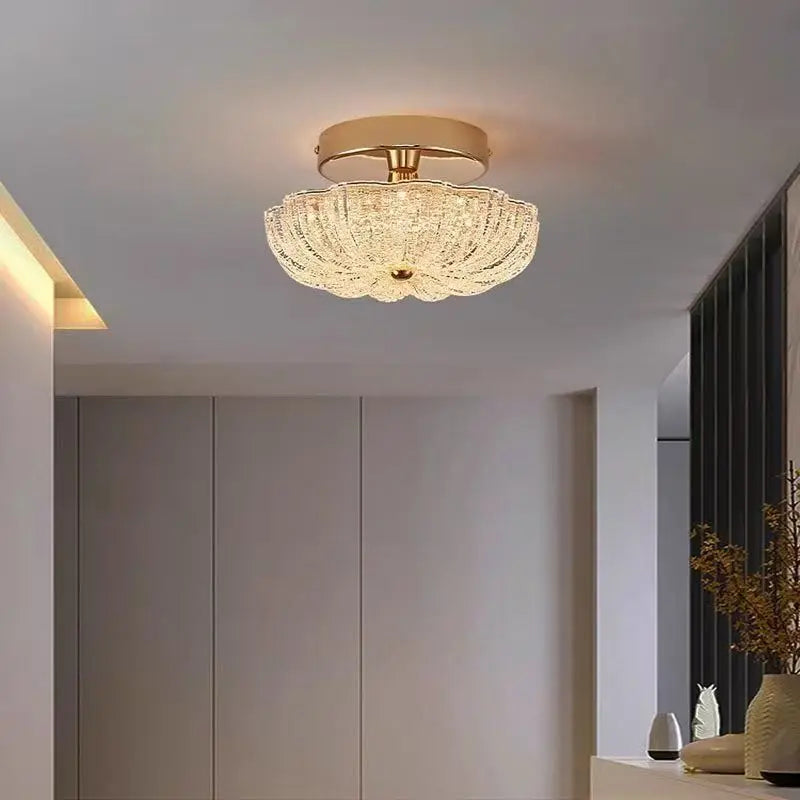 Gold flush-mount ceiling light with clear crystal-style acrylic drum shade