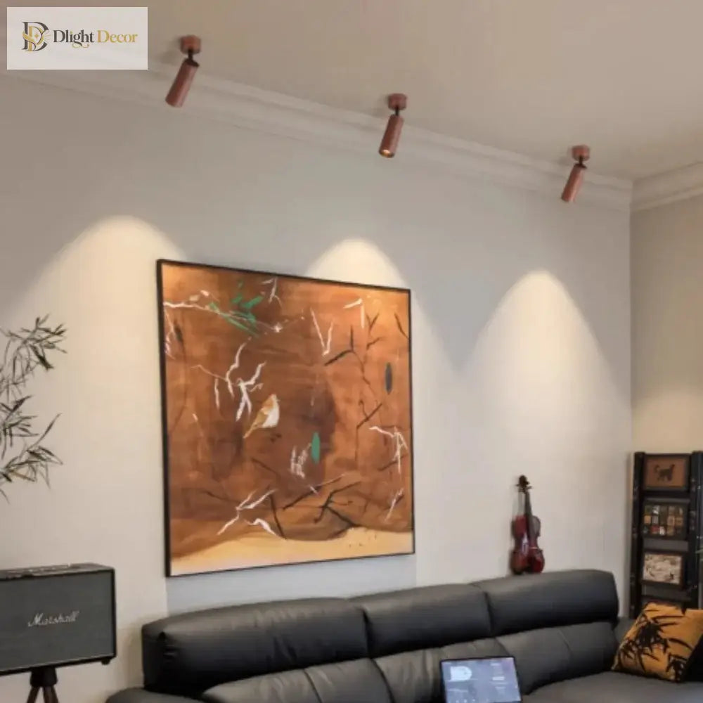 Walnut wood-grain LED spotlights installed on ceiling with a sofa and wall art nearby
