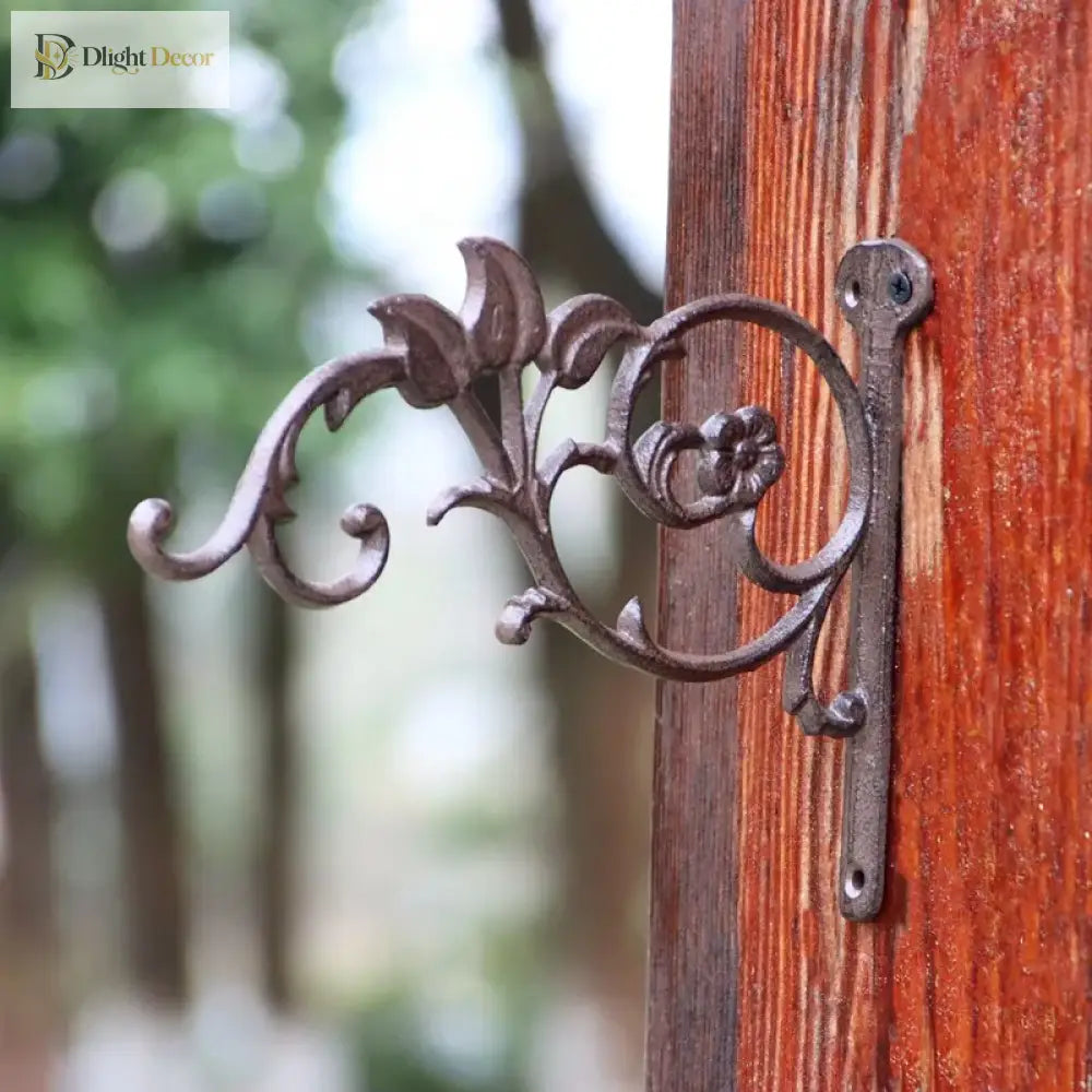 Cast iron right-angle wall shelf bracket with vine-like floral scroll and hook ends