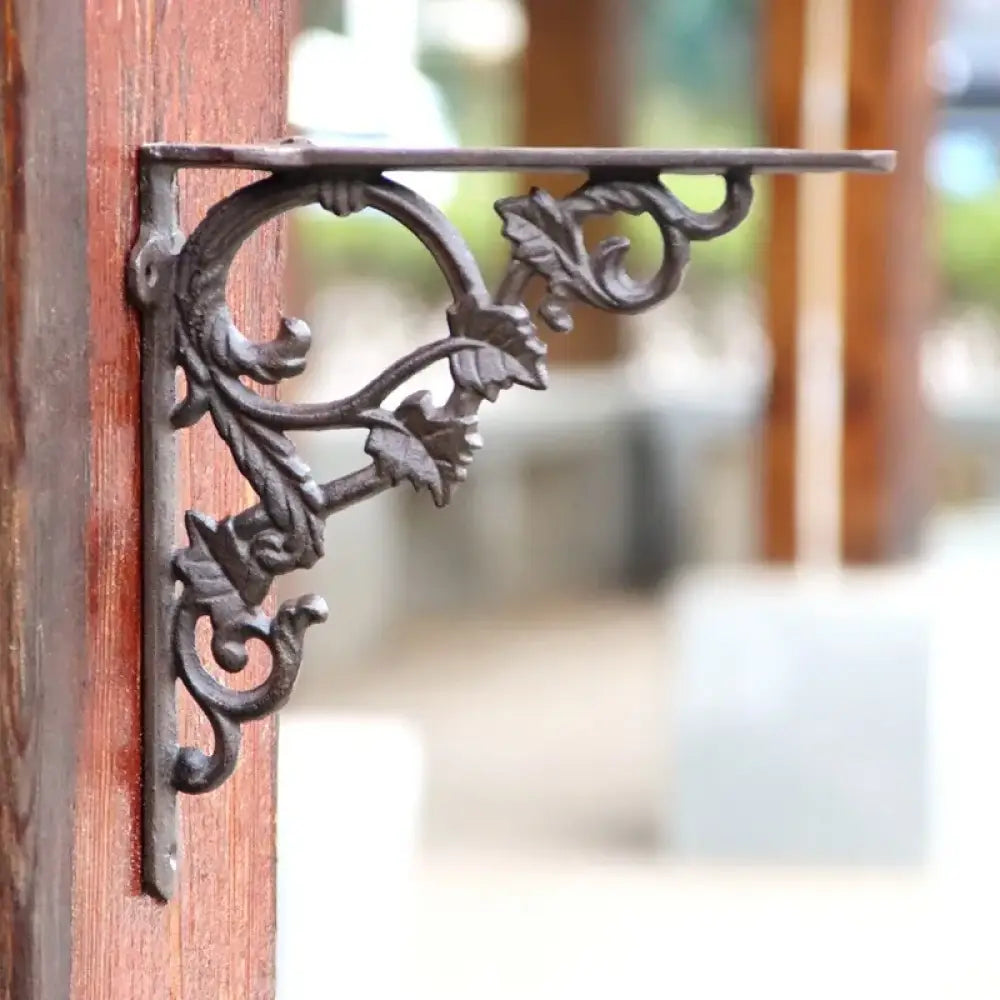 Cast iron flower shelf bracket with leaf and scroll detail, right-angle wall support