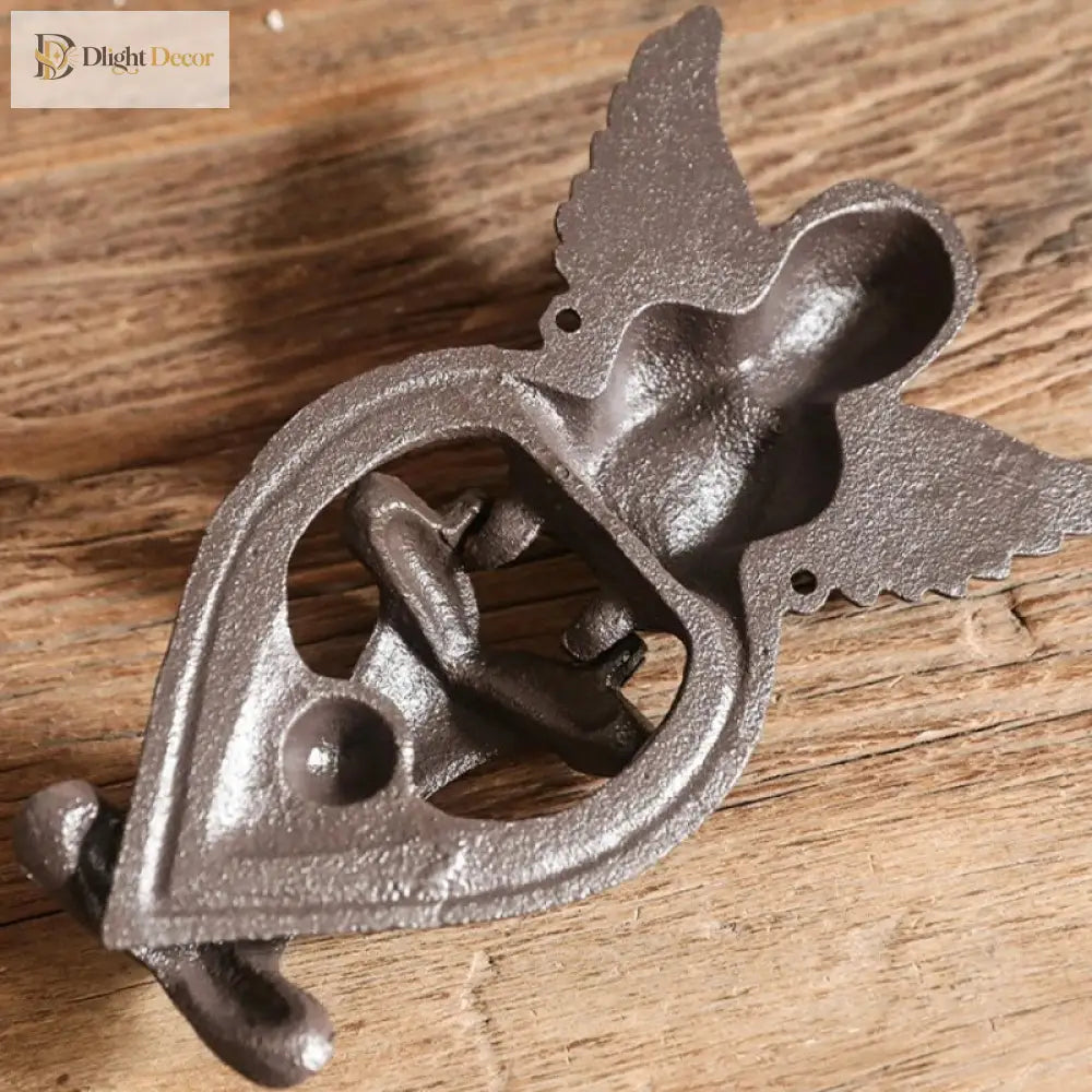 Cast iron angel door knocker close-up with heart knocker ring and winged figure, dark finish