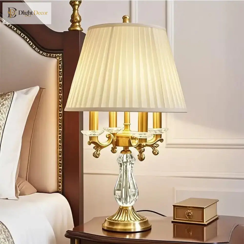Gold art deco desk lamp with pleated shade, clear crystal body, and ornate arms
