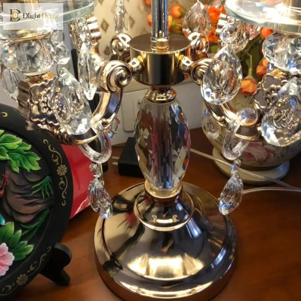 Close-up of gold crystal lamp base with faceted crystal arms and candle-style bulbs