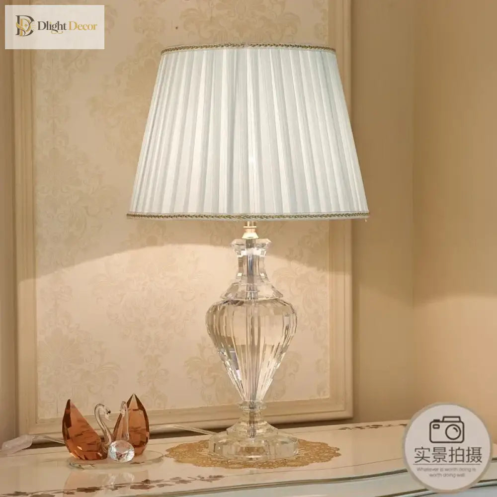 Crystal table lamp with pleated white shade and faceted clear base