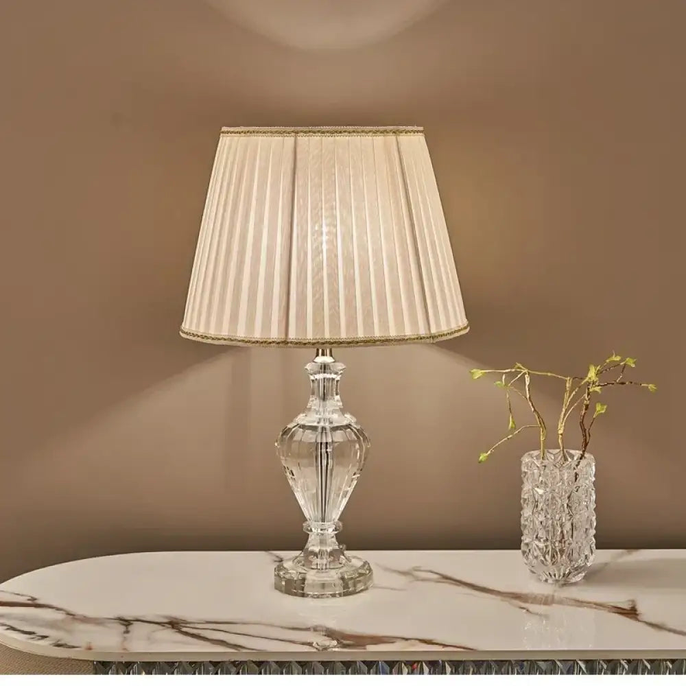 Crystal table lamp with pleated white fabric shade and clear faceted base