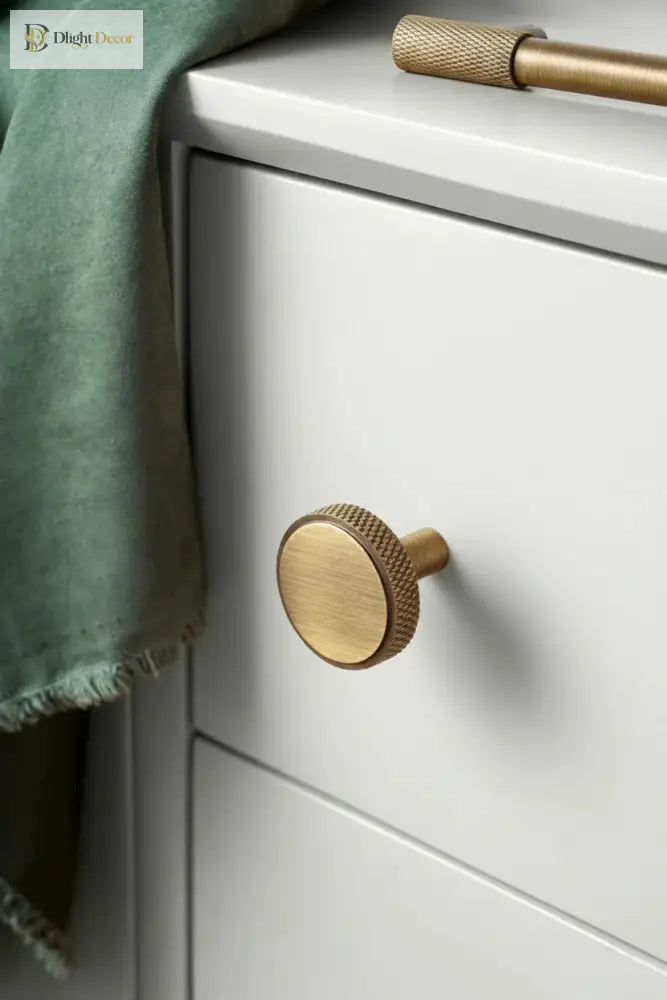 Antique brass round knob cabinet pull with cross-knurled textured edge, single post