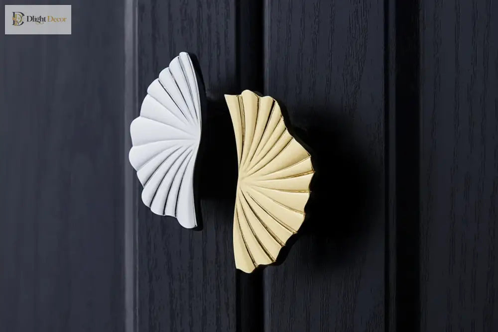 Ruffled cabinet handle pair with one bright silver and one PVD gold finish on dark doors.