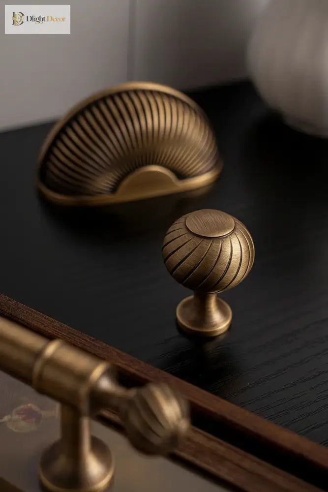 Brushed brass cabinet knob with ribbed shell dome and round base