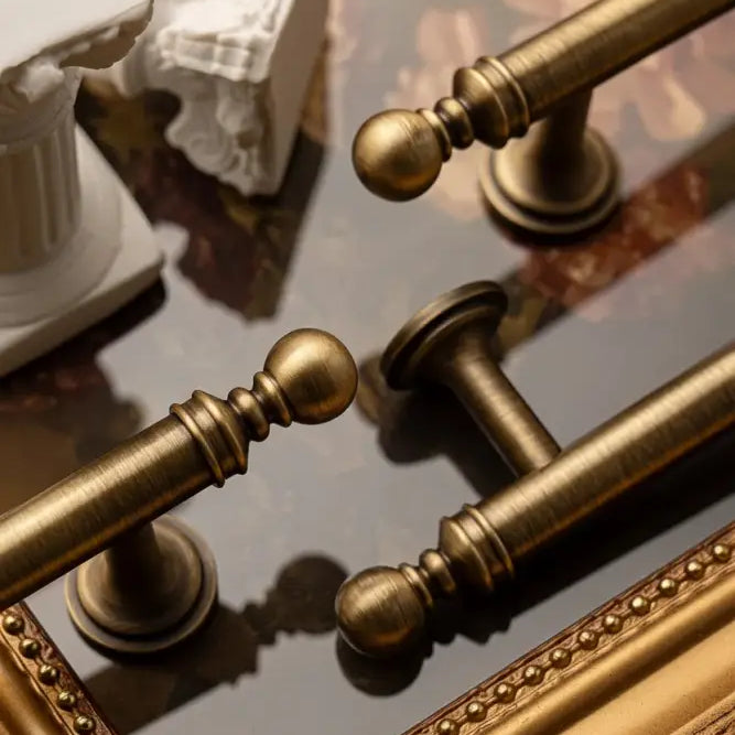 Brushed brass T-bar cabinet pull detail with round knobs and matching curved wall mounts