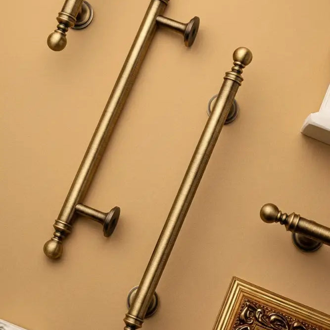 Brushed brass T-bar cabinet pull showing round finial ends and cylindrical support posts