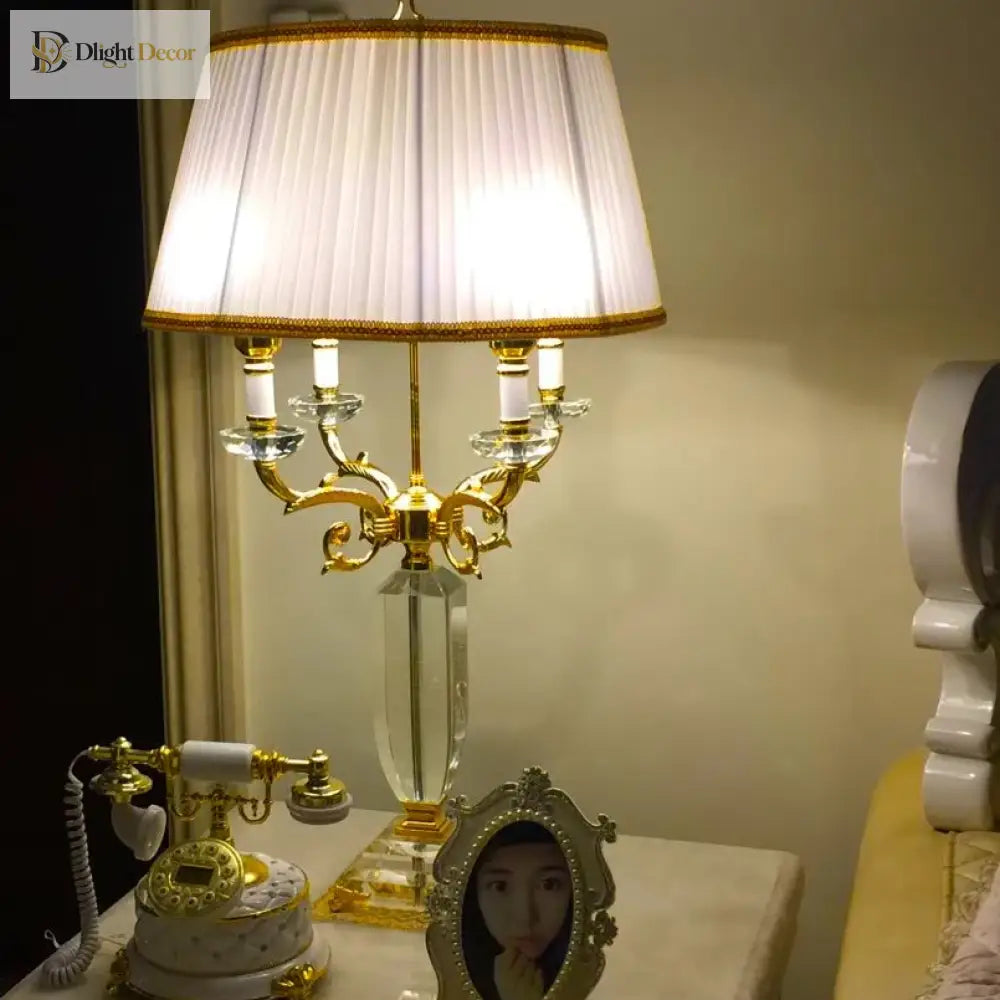 Fabric LED table lamp with lit pleated cream shade and gold crystal-style candelabra base