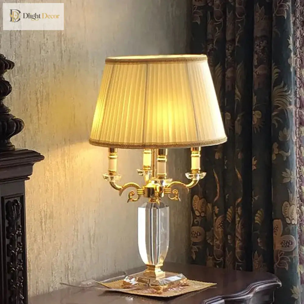 Fabric LED table lamp with pleated cream shade, gold candelabra arms, and crystal stem