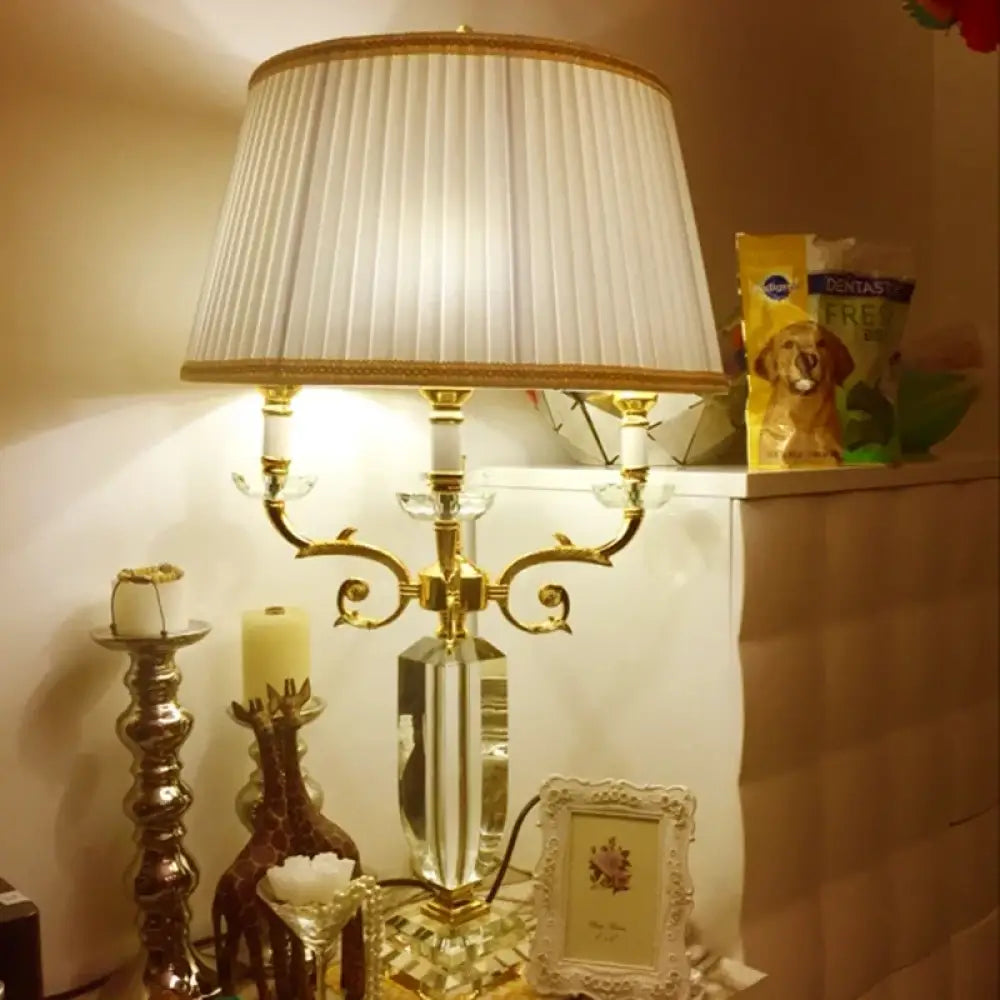Fabric LED table lamp with pleated cream fabric shade and ornate gold candelabra base
