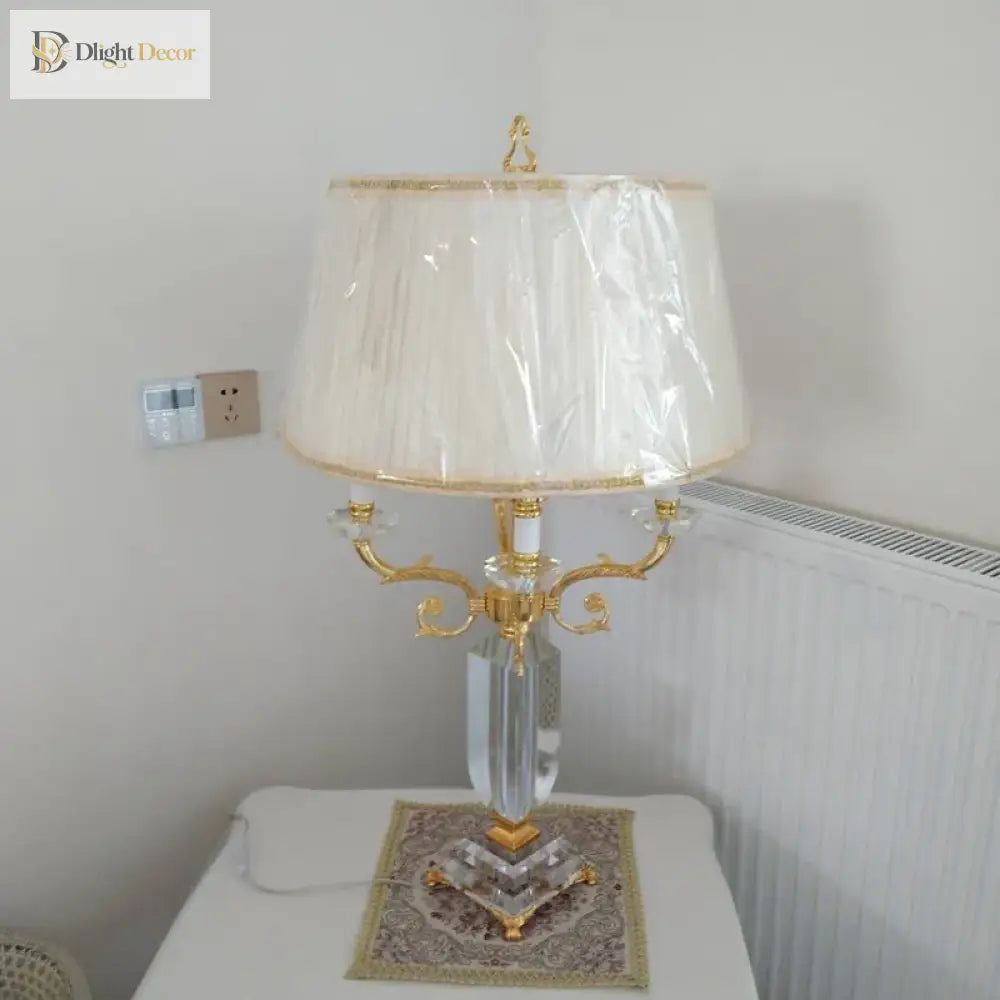 Fabric LED table lamp with pleated cream shade (plastic cover) and gold arms, clear base
