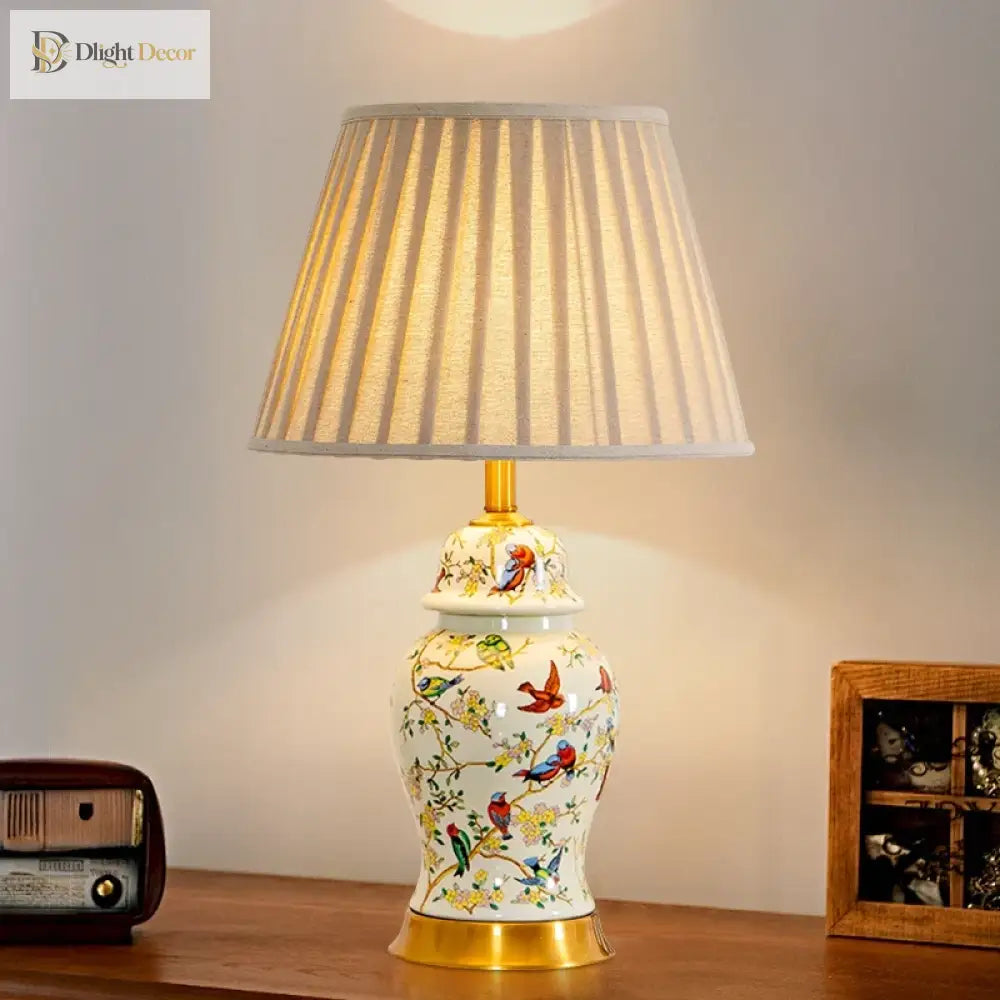 Floral ceramic lamp with gold base and pleated fabric shade for bedside tables.