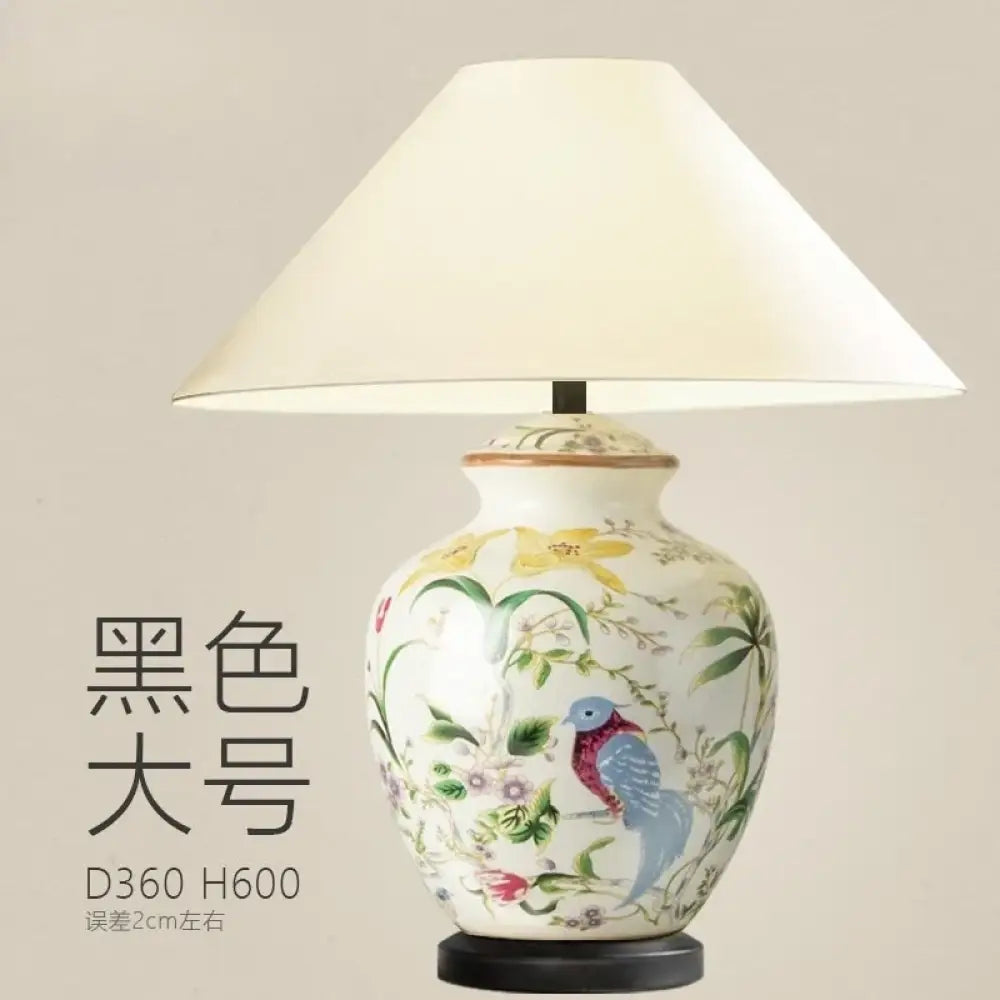 Ceramic table lamp with white shade and blue bird motif on a larger vase base
