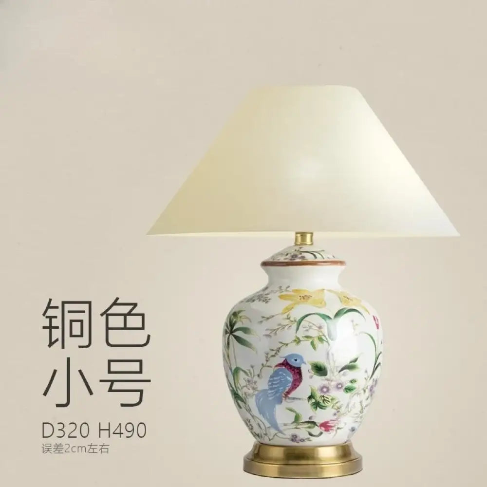 Ceramic table lamp with white shade and blue bird motif on a copper base