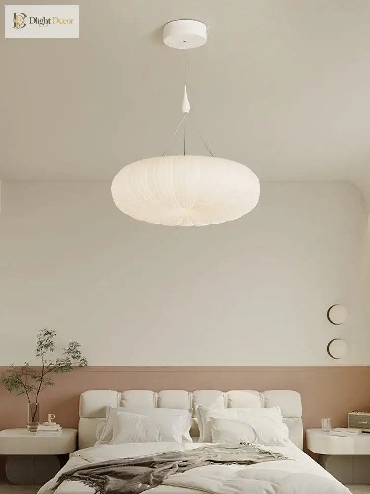 Cream pendant ceiling light with ribbed dome shade above a bed