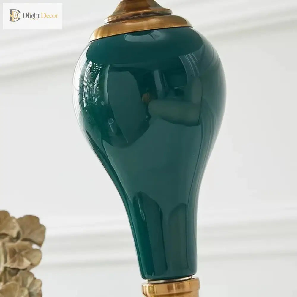 Close-up of green ceramic lamp base with glossy finish and gold metal collar