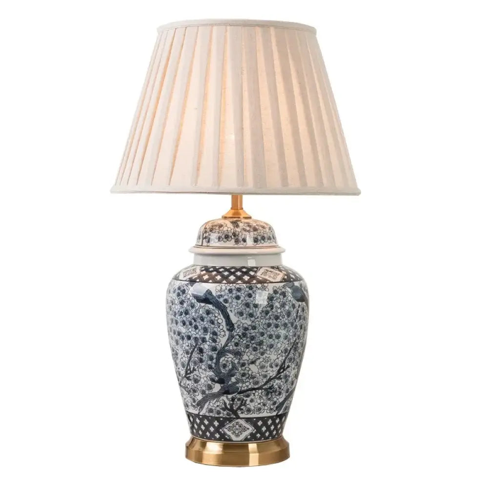 Indigo patterned ceramic lamp with beige pleated drum shade and gold base detailing