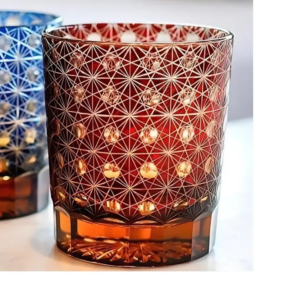 Red cut crystal whisky glass with white geometric web pattern and amber base