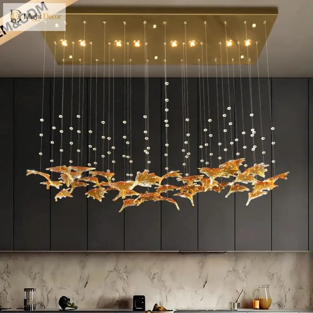 Modern pendant chandelier with warm bulbs, clear cords, and gold glass leaf centerpiece