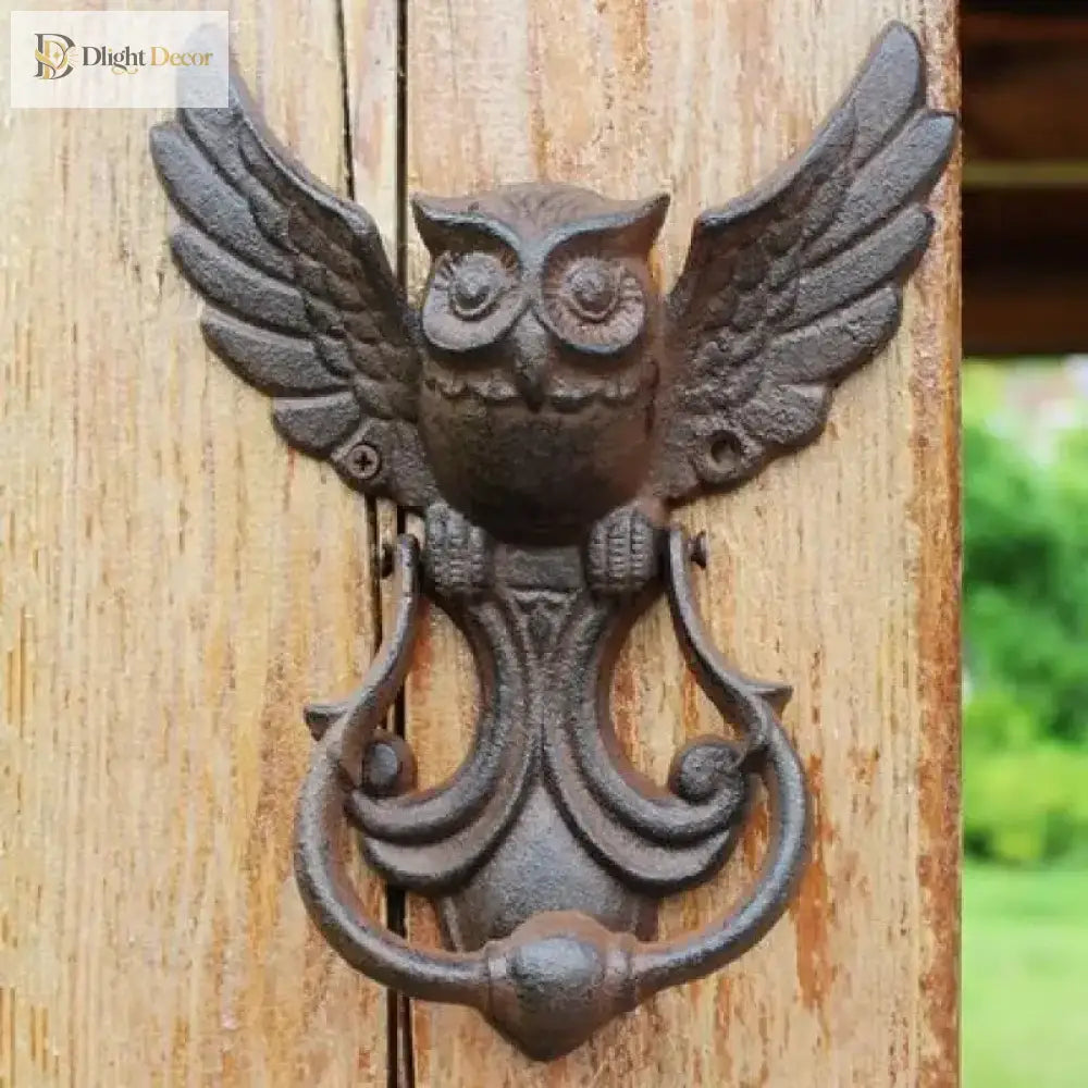 Cast iron owl door knocker, front view with wide wings and arched handhold on a door