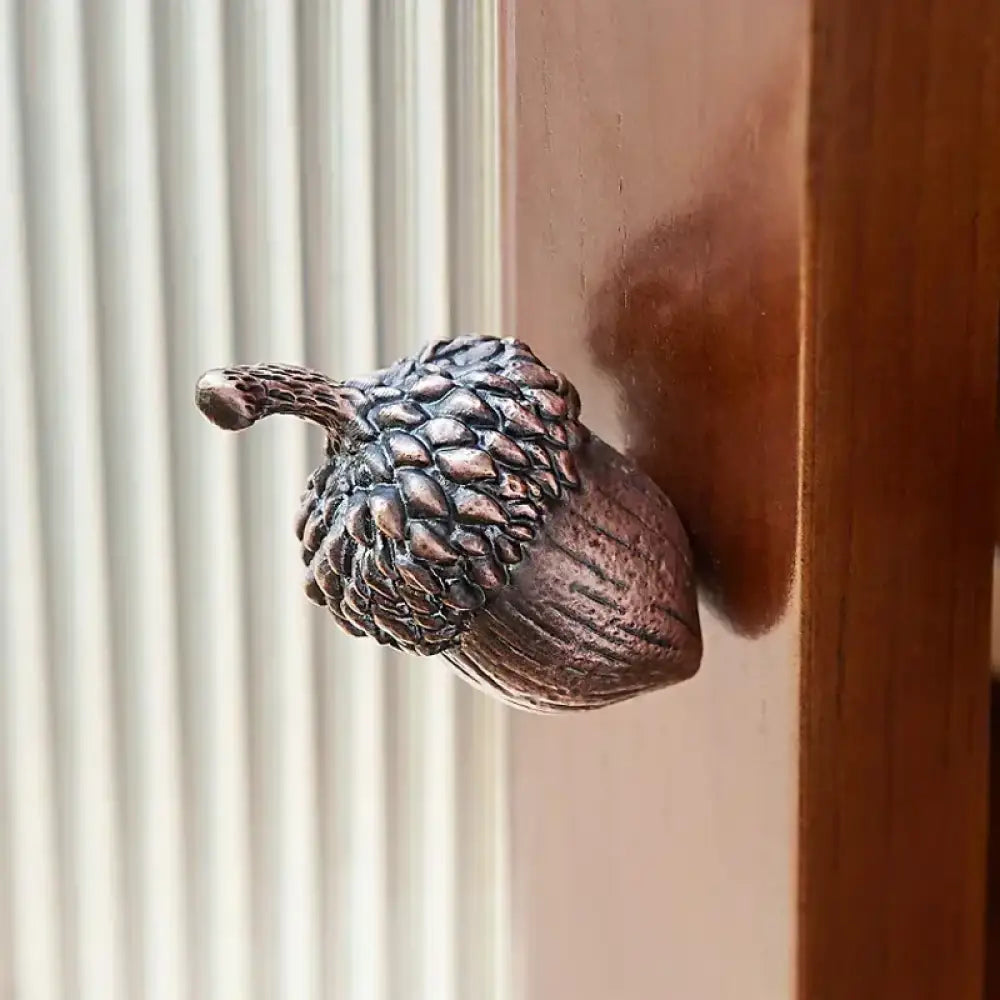 Textured metal acorn knob mounted on a wardrobe door panel