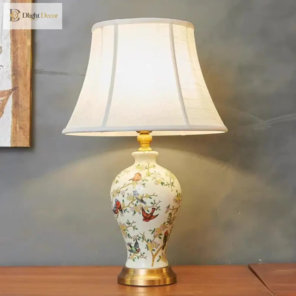 Floral ceramic table lamp with white pleated fabric shade and brass foot