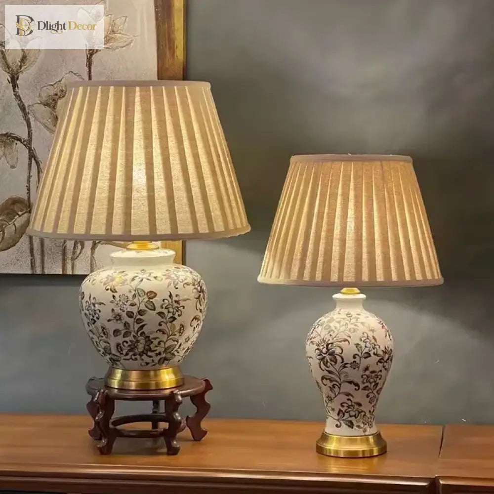 Pair of floral ceramic table lamps with pleated shades on a console