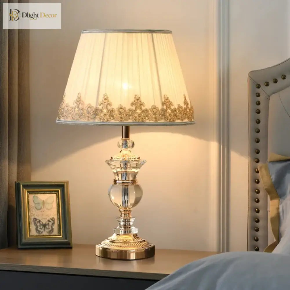 Crystal bedside lamp with pleated white shade and ornate silver stand