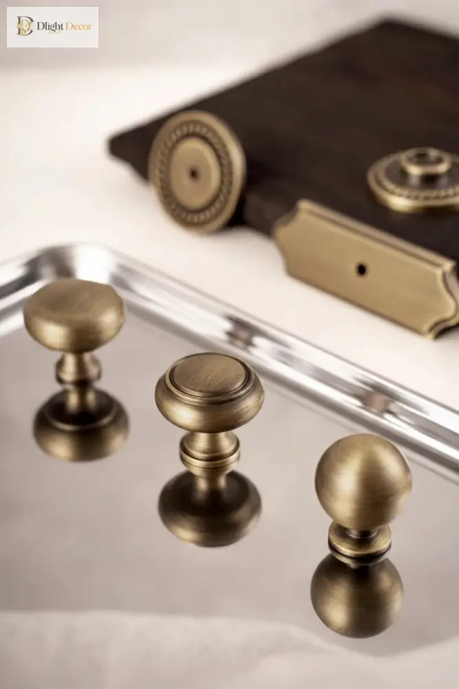 Solid brass single-hole cabinet handles with round knobs and mixed backplates, antique bronze finish