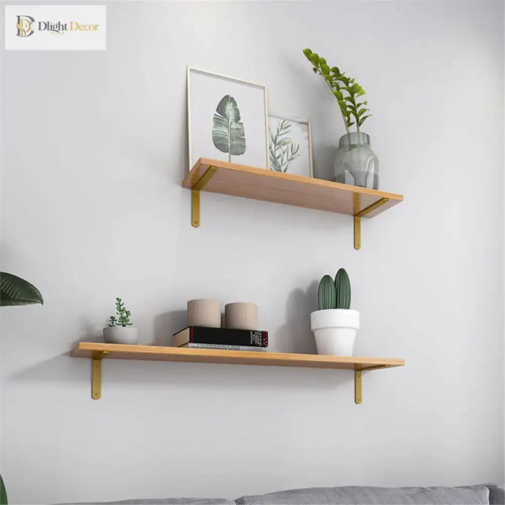 Gold L-shaped shelf brackets supporting a wood wall shelf in a home display