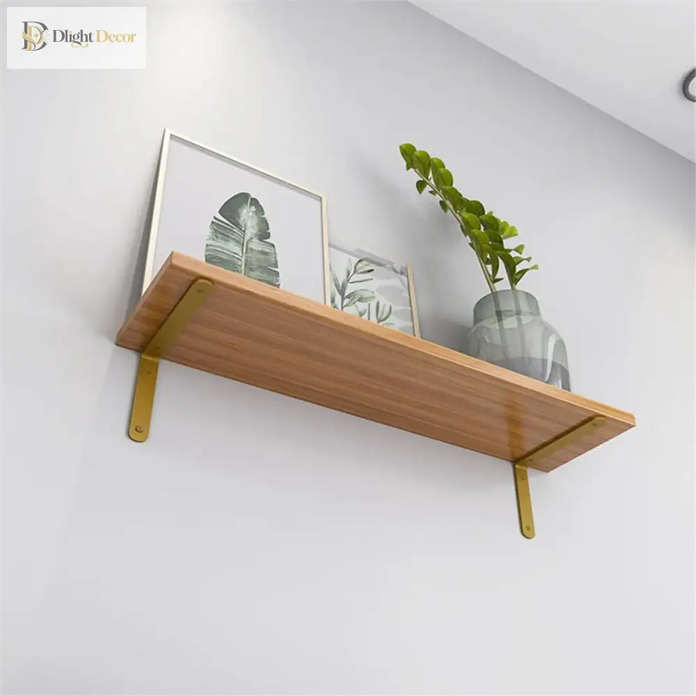 Gold L-shaped shelf brackets mounted under a wood shelf for wall storage