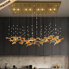 Modern pendant chandelier with warm bulbs, clear cords, and gold glass leaf centerpiece