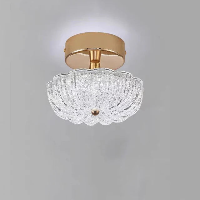 Gold flush-mount ceiling light with clear crystal-style acrylic drum shade