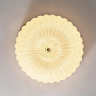 Round scalloped acrylic diffuser for a flush-mount LED ceiling light with brass center
