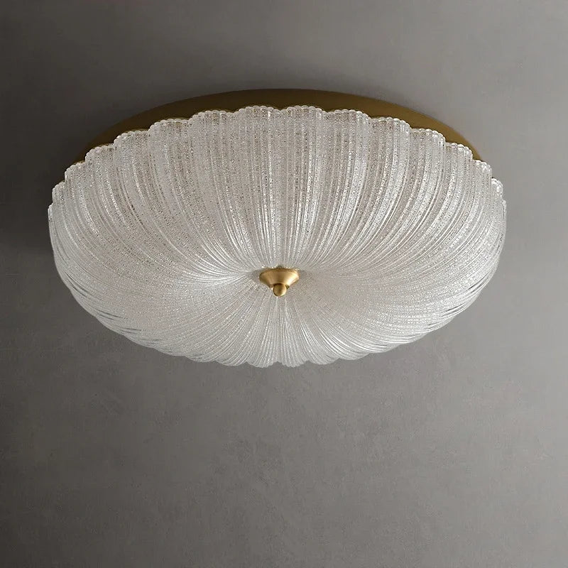 White crystal-style acrylic LED flush-mount ceiling light with scalloped diffuser and brass cap