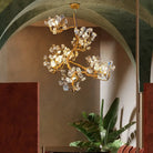 Gold-toned crystal chandelier with sculpted branching arms and sparkling clear prisms