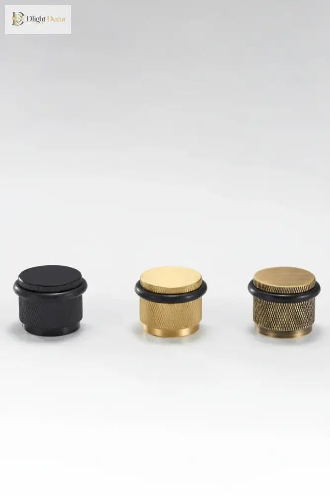 Set of four adjustable knurled floor door stops in black and gold finishes with black rings