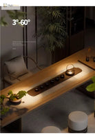Adjustable LED zoom spotlight projecting a warm beam onto a sofa and rug in a room