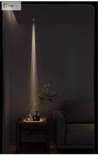 Adjustable LED zoom spotlight casting a narrow warm light beam on a console table plant