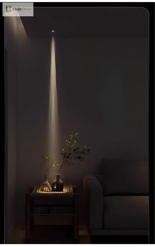 Adjustable LED zoom spotlight casting a narrow warm light beam on a console table plant