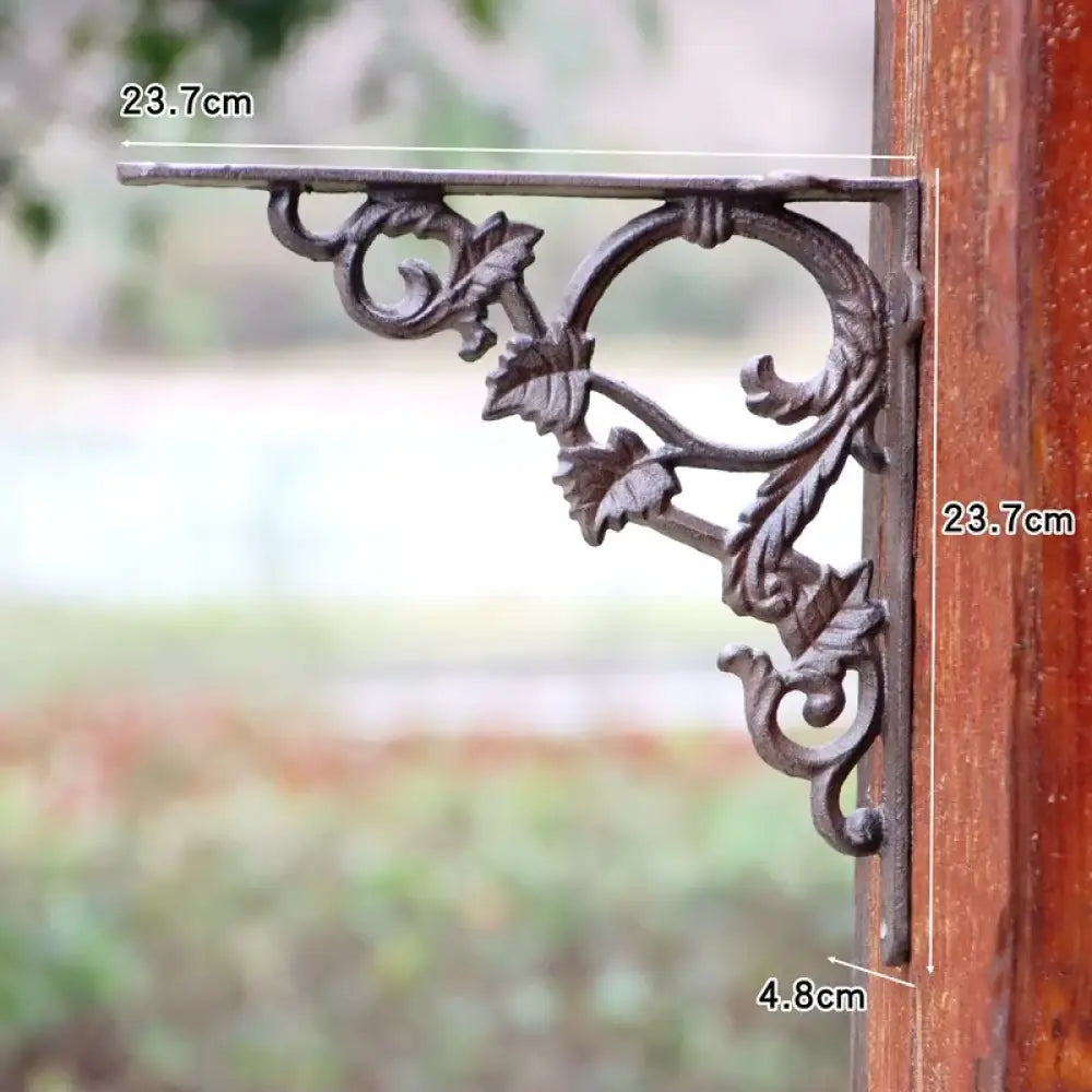 Cast iron wall shelf bracket with arched floral scrollwork and horizontal mounting bar