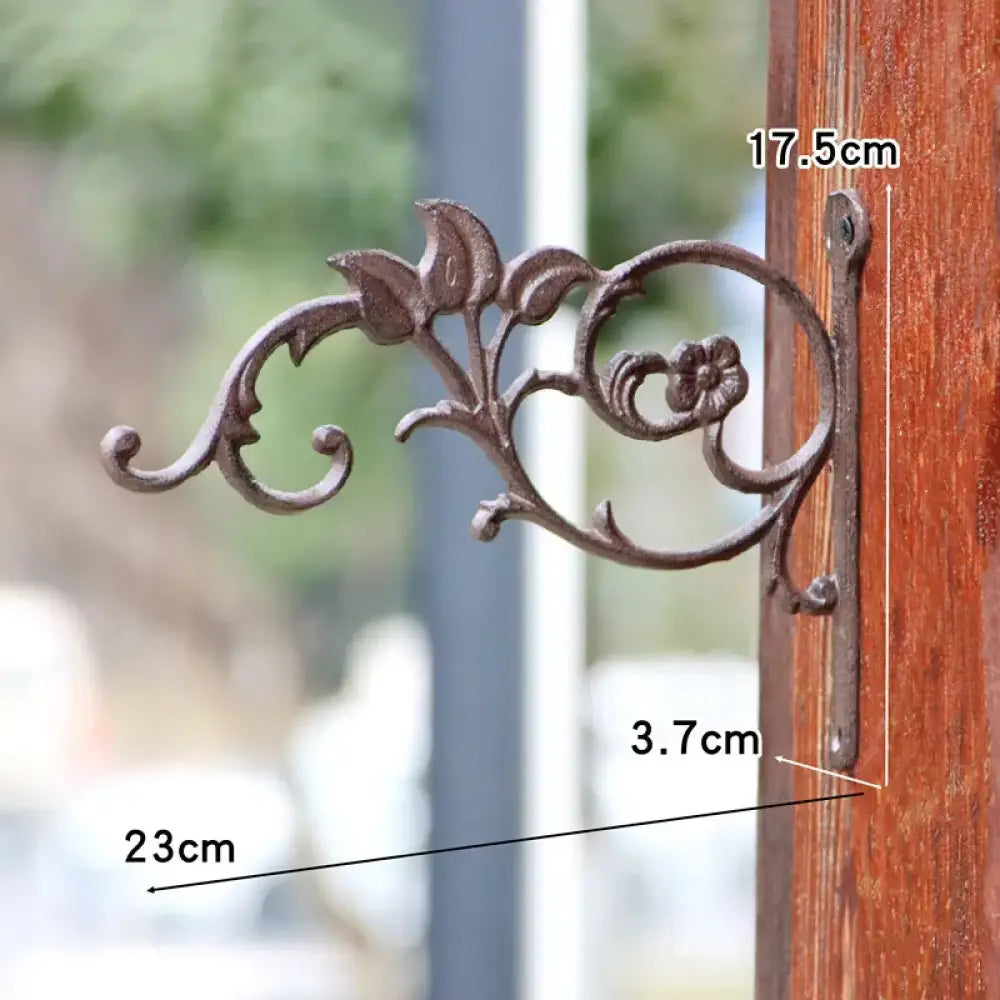 Cast iron flower shelf bracket with oval ring floral ornament and curled leaf ends