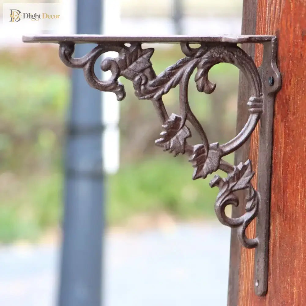 Cast iron flower shelf bracket with ring scroll detail and leaf accents