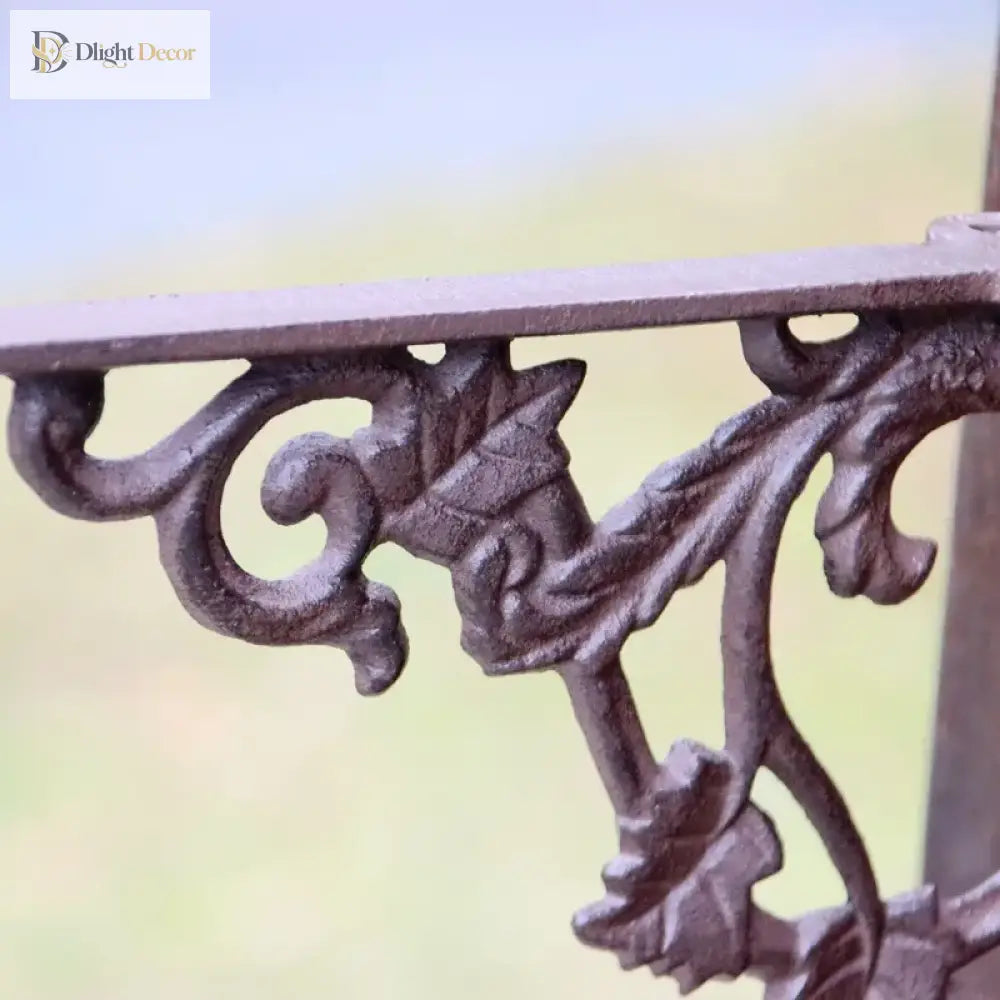 Cast iron decorative shelf bracket close-up with leaf scrollwork under top rail